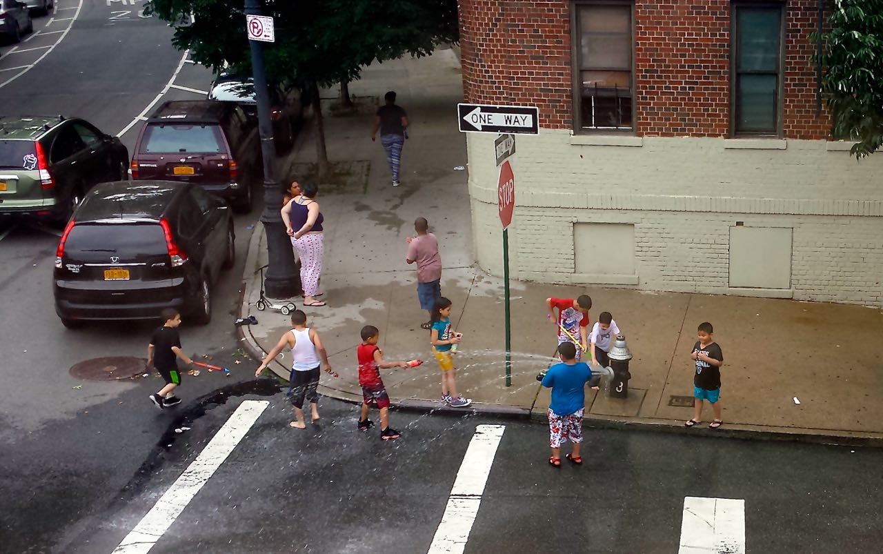 CHILDREN GATHER AROUND the capped fire hydrant on the corner of Putnam Place. Photo by Vivian Carter