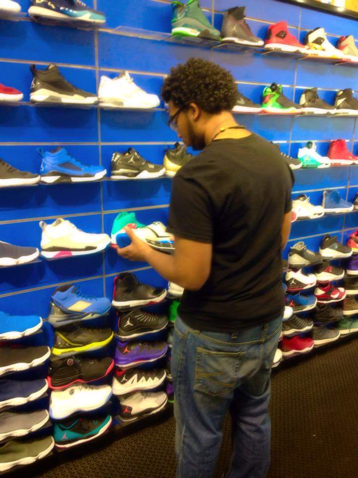 THIS TEEN CHECKS out this large display of sneakers at a Bronx shoe store.  Photo by Medelin Cuevas  