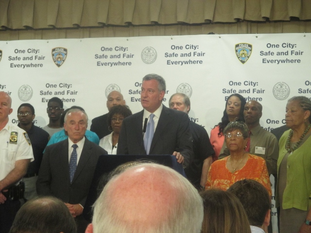 MAYOR BILL DE BLASIO, flanked by NYPD Commissioner Bill Bratton (left) and 47th Precinct Community Council President Elizabeth Gill, announces the “One City: Safe and Fair Everywhere” on July 15.  Photo by David Cruz 