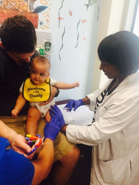 NEVER TOO EARLY. A nurse administers a vaccine to this infant, just one of many doses required to enter school. Doctors recommend children receive their shots early. Photo courtesy Montefiore Medical Center 