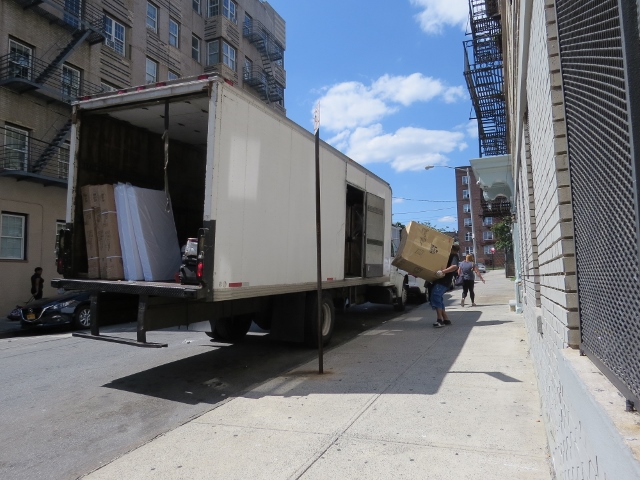 MOVERS HAUL OUT appliances and furniture intended for several apartments at 319 E. 197th St. purported to have been set aside for homeless residents. Photo by David Cruz 