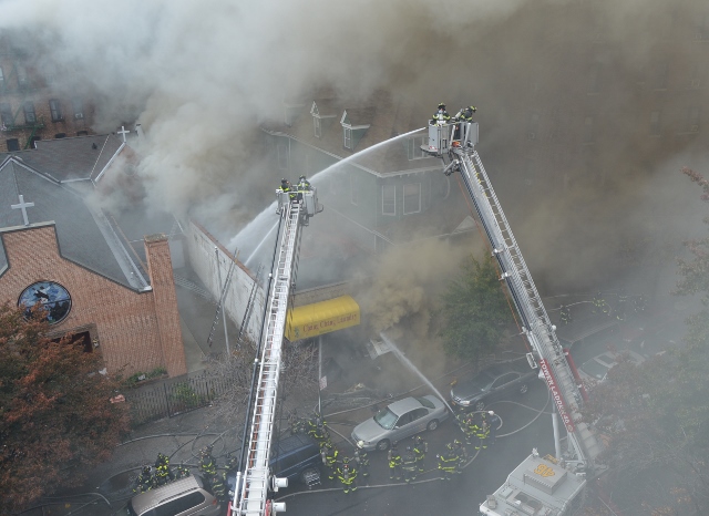 FIRE CREWS SPENT two hours knocking out this three-alarm fire that began at 358 Bedford Park Boulevard next to St. Mary's Orthodox Church (left). Photo by David Cruz