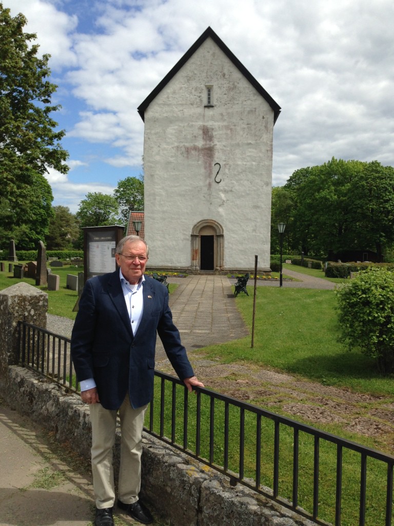 CURT WRIGFORS, DIRECTOR of the Jonas Bronck Center in Sävsjö, Sweden stands at 12th century Norra Lunga Church where Jonas Bronck was baptized. Photo courtesy Janet Norquist-Gonzalez 