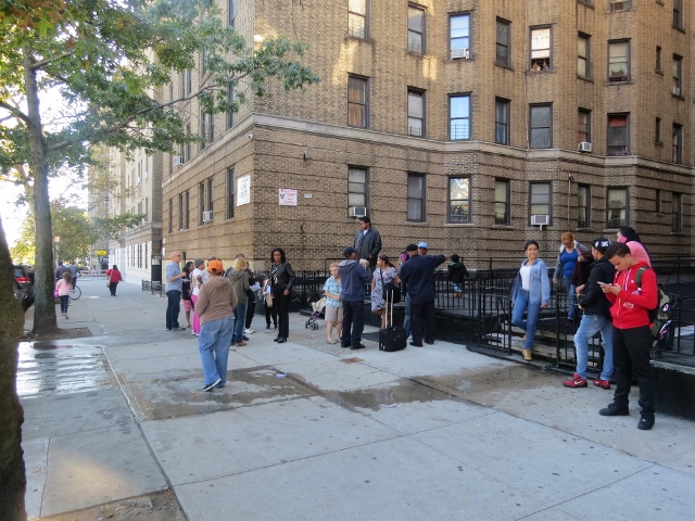 TENANTS AT 2701 Grand Concourse mill about as they await fire crews to clear them for re-entry into the building. Photo by Jasmine Gomez