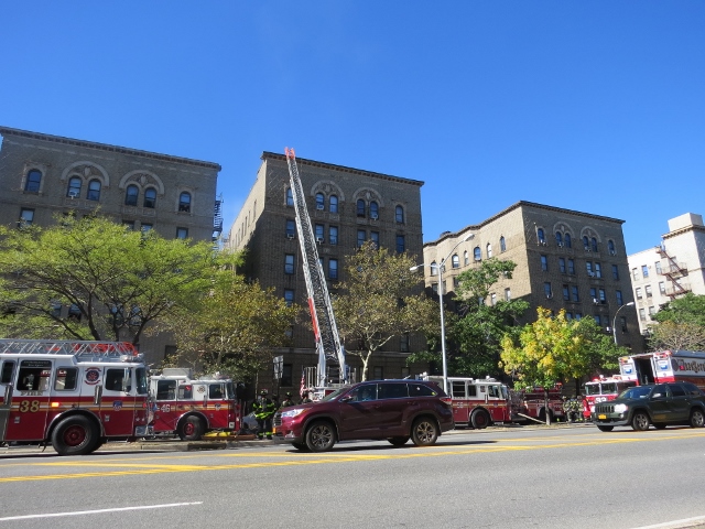 FIRE CREWS USE a ladder to reach the roof of 2701 Grand Concourse. Photo by David Cruz 