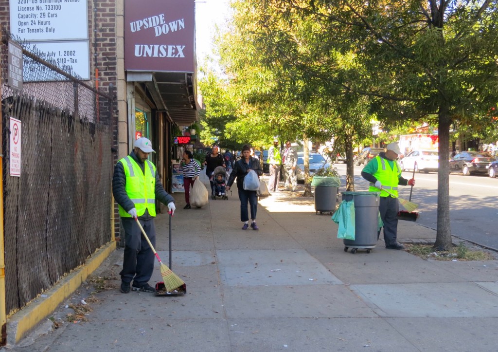 WORKERS SWEEP UP debris along Bainbridge Avenue at 207th Street as part of a cleanup service funded through Councilman Andrew Cohen’s office.  Photo by Adedamola Agboola 