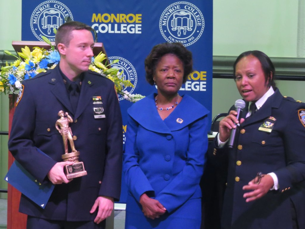 OFFICER JAMES LUNDY (left) stands alongside Brenda Caldwell-Paris, 52nd Precinct Community Council President, and 52nd Precinct Inspector Nilda Hofmann after receiving the Police Officer of the Year Award.  Photo by Jasmine Gomez  