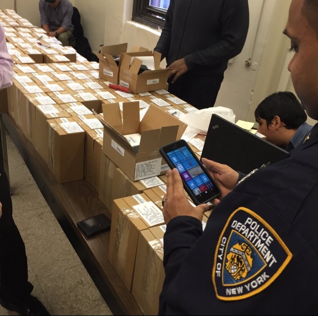 POLICE OFFICERS AT the 52nd Precinct try out their new NYPD-issued phones intended to streamline crime fighting duties.  Photo courtesy NYPD  