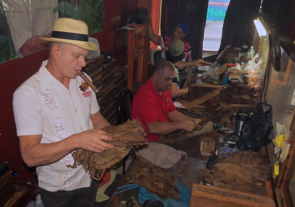 FRANCISCO ROSARIO, OWNER of Rosario’s Cigars LLC, stands at the cigar making station as workers prepare the next batch of cigars. Photo by David Cruz 