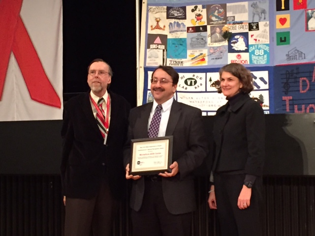 DR. BARRY SIGMAN, , (center) accepts an award for leading the fight against AIDS alongside health officials. Photo courtesy NYC Department of Health 